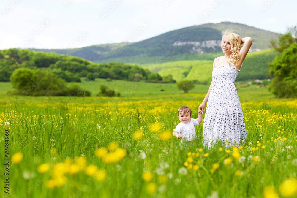 young woman playing with her child in flowers field young woman playing with her child in flowers field