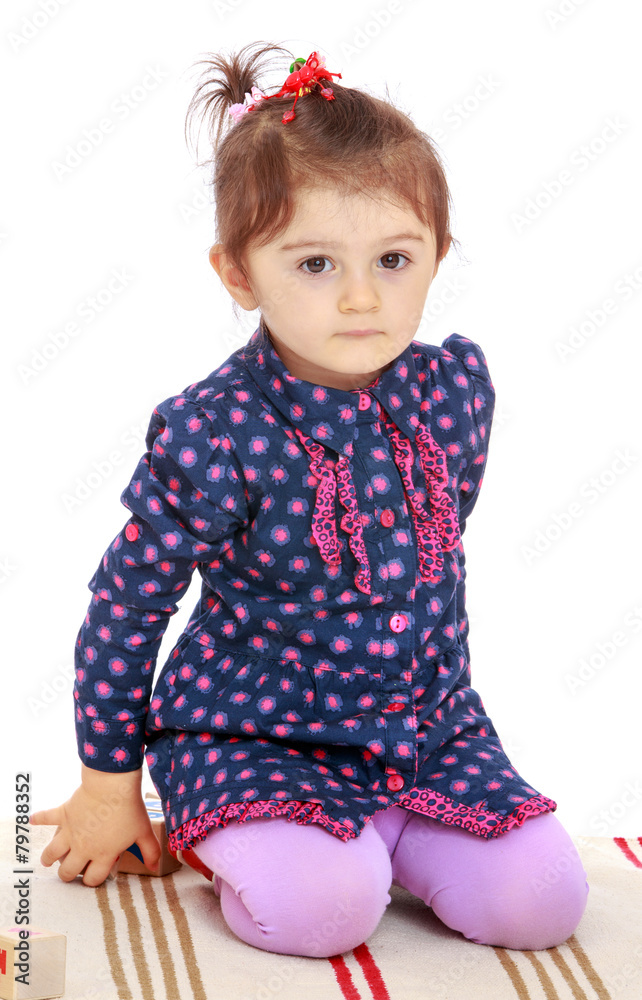 very serious little girl sitting on a rug very serious little girl sitting on a rug