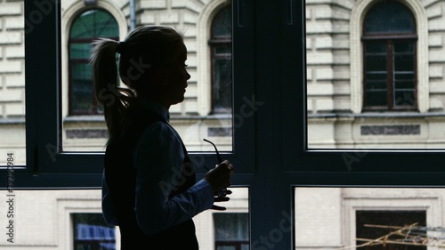 Businesswoman standing at the window after a busy day photo