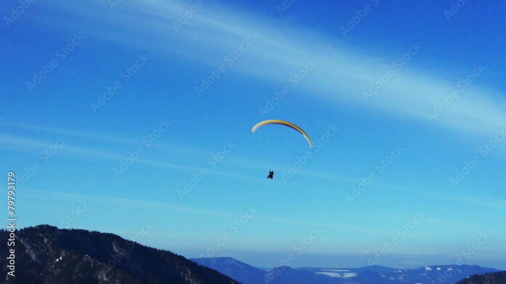 Colorful hang glider in sky over mountains Colorful hang glider in sky over mountains