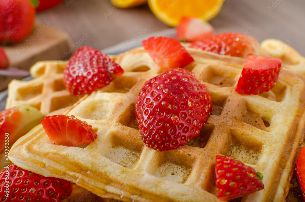 Homemade waffles with maple syrup and strawberries Homemade waffles with maple syrup and strawberries