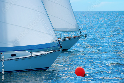 Sailboats rounding a buoy in a race regatta