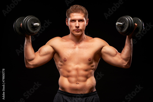 Serious powerful shirtless muscular sportsman pumping biceps