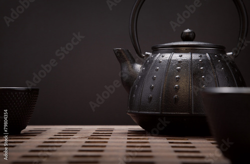 Image of traditional eastern teapot and teacups on wooden desk photo
