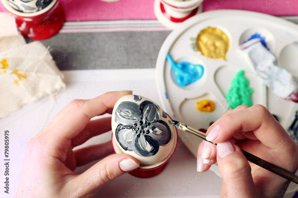 Young woman painting Easter eggs on table close up Young woman painting Easter eggs on table close up