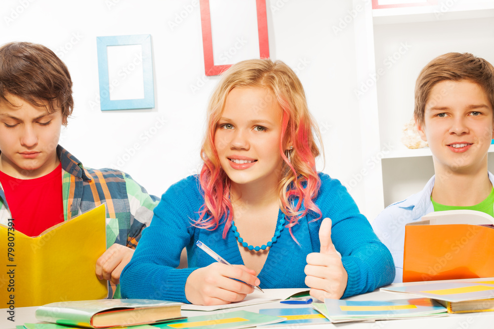 Thumb up homework - girl with friends at home Thumb up homework - girl with friends at home