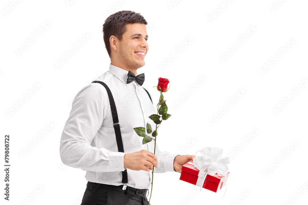 Elegant guy walking with a rose and a present Elegant guy walking with a rose and a present