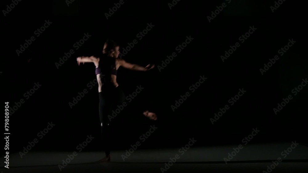 Jumping girl dancing contemp in the shadow on black background Jumping girl dancing contemp in the shadow on black background