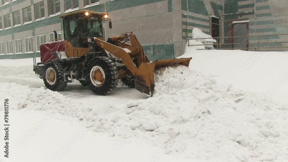 Snowplow removes a lot of snow in the city Snowplow removes a lot of snow in the city