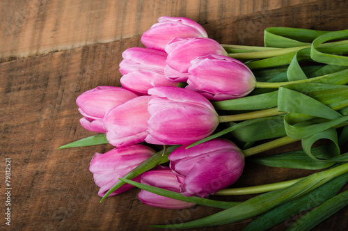 Bouquet of pink tulips on a wooden table