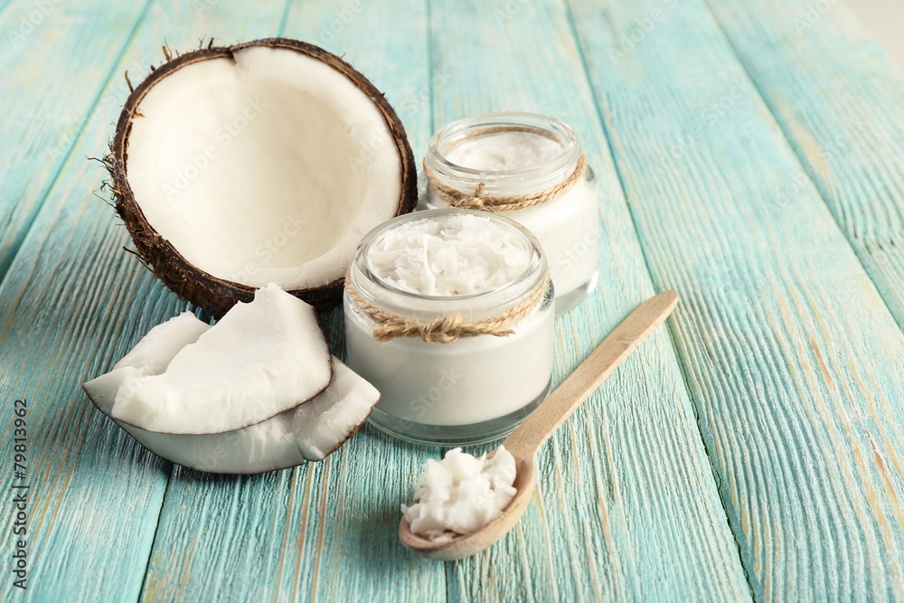 Fresh coconut oil in glassware and wooden spoon Fresh coconut oil in glassware and wooden spoon