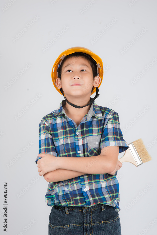 Asian boy in a protective helmet with brush in his hand Asian boy in a protective helmet with brush in his hand