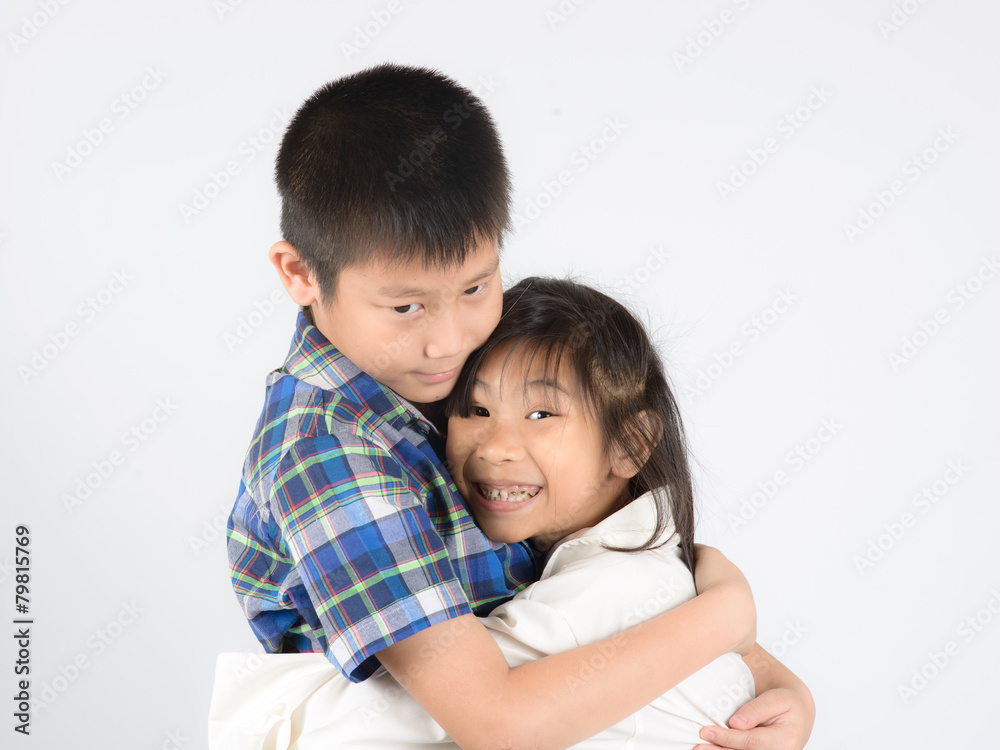 Loving brother and little sister hugging on gray background. Loving brother and little sister hugging on gray background.