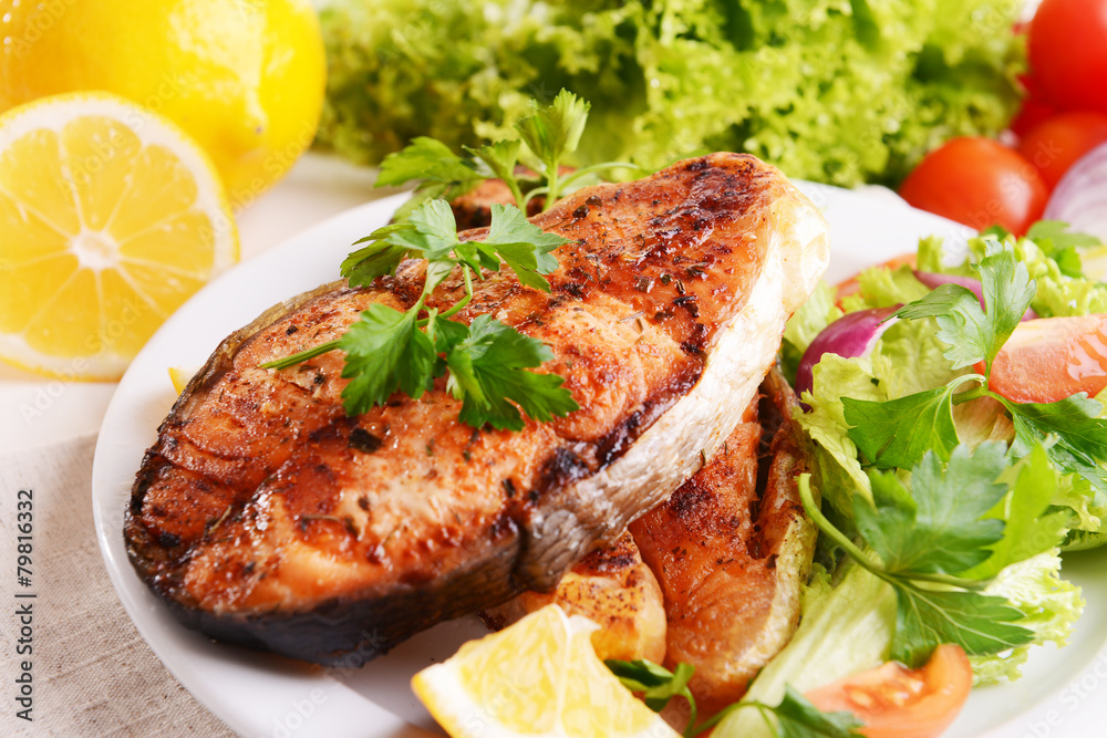 Tasty baked fish on plate close-up