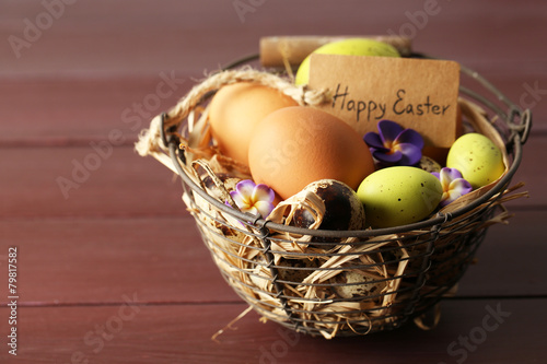Bird eggs in wicker basket with decorative flowers