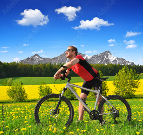 Cyclist with the mountain bike in spring landscape