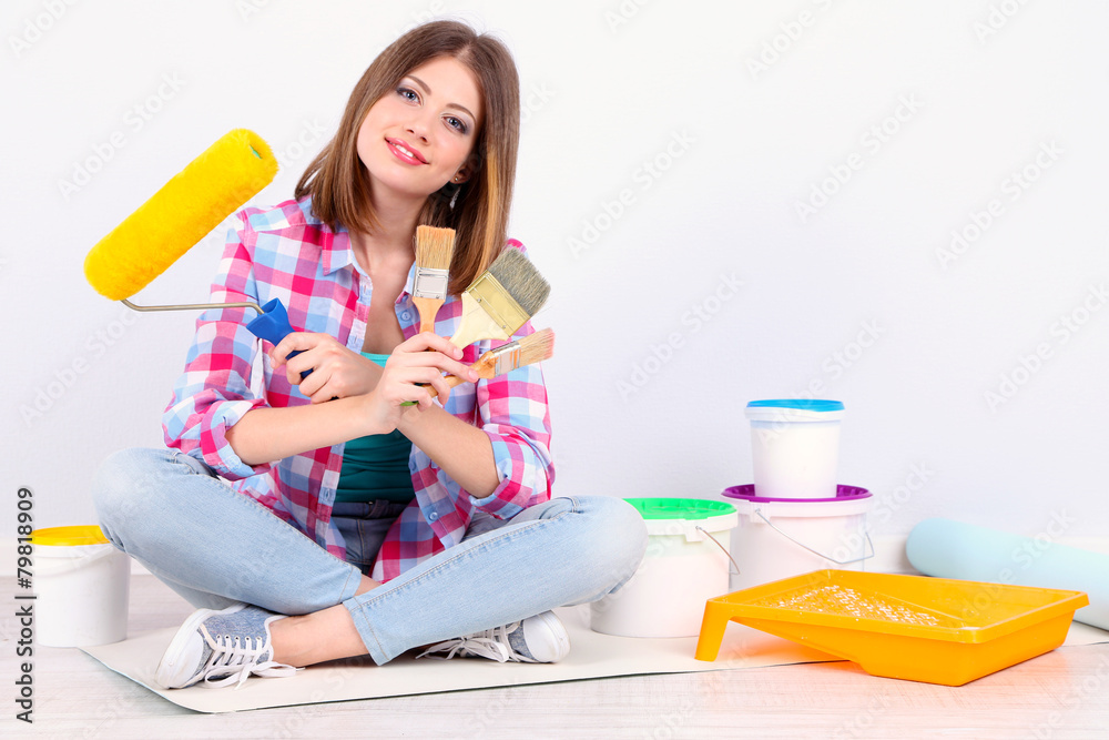 Beautiful girl sitting on floor with equipment for painting Beautiful girl sitting on floor with equipment for painting