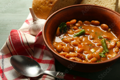 Bean soup in bowl on napkin, on wooden table background