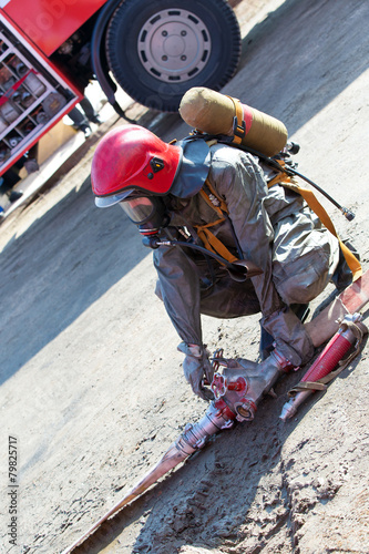 Fireman connecting firehose during fire fighting and rescue work