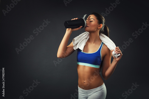 Attractive young woman drinking proteins