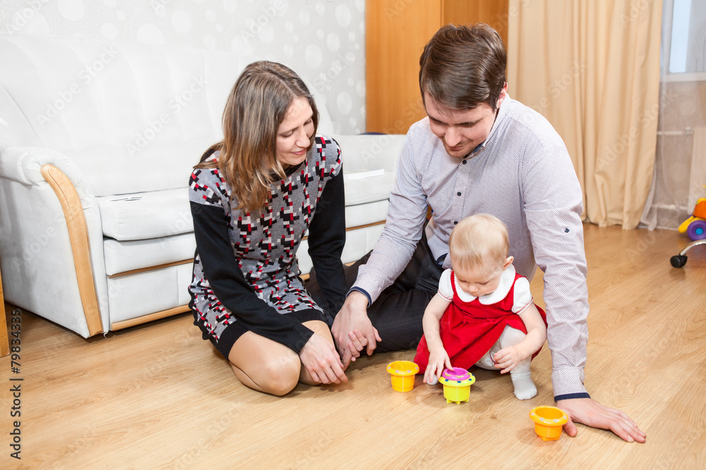 Naklejka premium Three people Caucasian family playing on floor in room