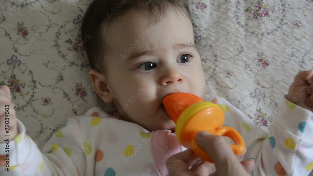 Baby licking object with a piece of food Baby licking object with a piece of food