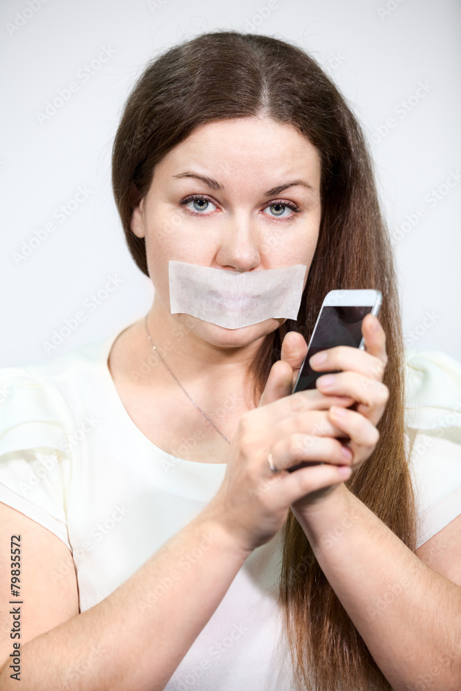 Attractive woman with mouth sealed can not talk on a cell phone Attractive woman with mouth sealed can not talk on a cell phone