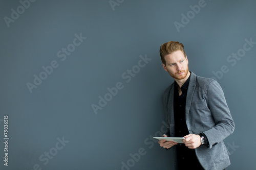 Man with tablet by the wall