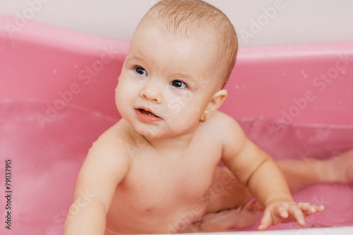 child bathes in a bathroom. playing in the water