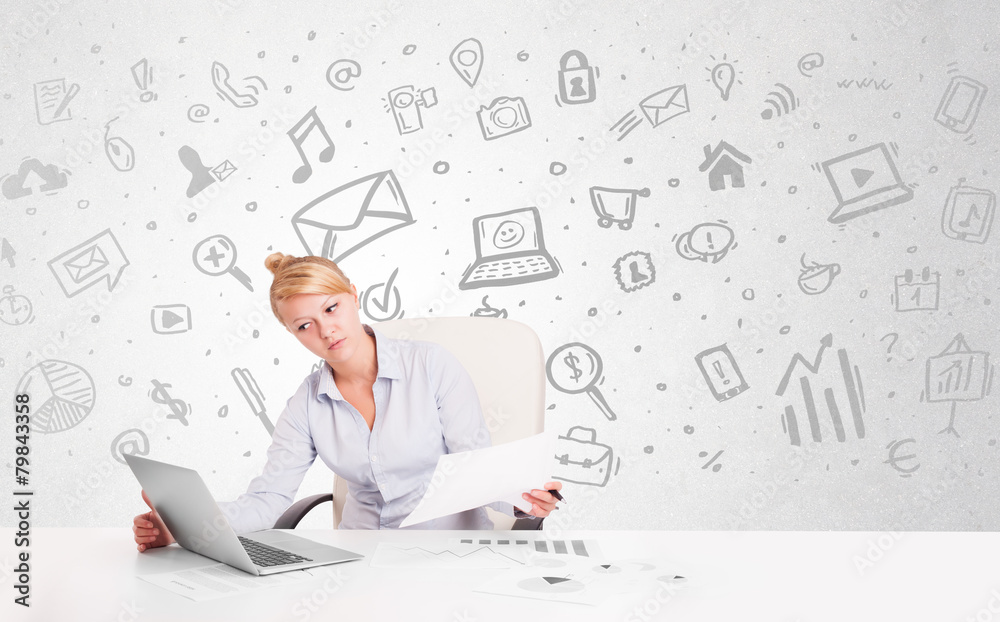 Business woman sitting at table with hand drawn media icons Business woman sitting at table with hand drawn media icons