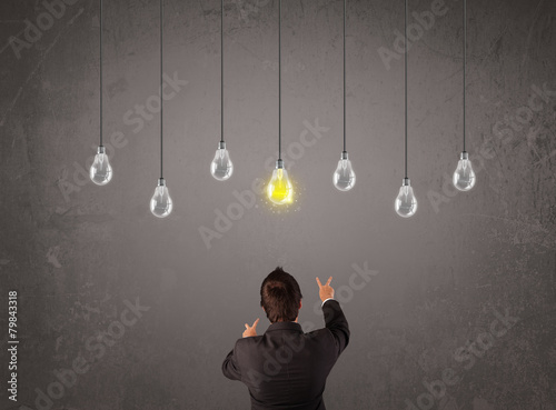 Businness guy in front of idea light bulbs concept photo