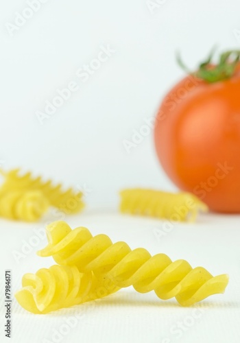 Spiral shaped pasta pieces on white background with copy space