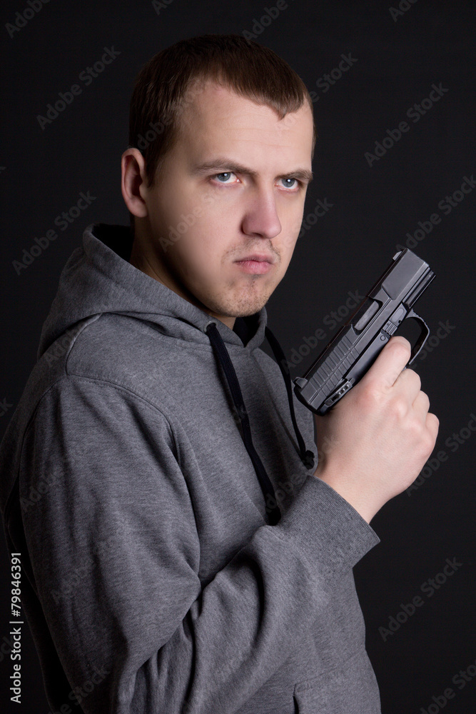 young man criminal holding gun over grey young man criminal holding gun over grey