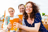 Freunde prosten mit Bier im Biergraten 