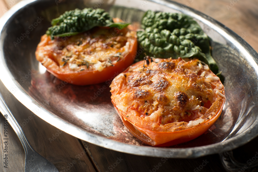 Baked tomato halves covered in cheese and spices Baked tomato halves covered in cheese and spices