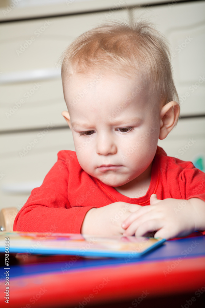 Small toddler or a baby child playing with puzzle shapes on a lo Small toddler or a baby child playing with puzzle shapes on a lo