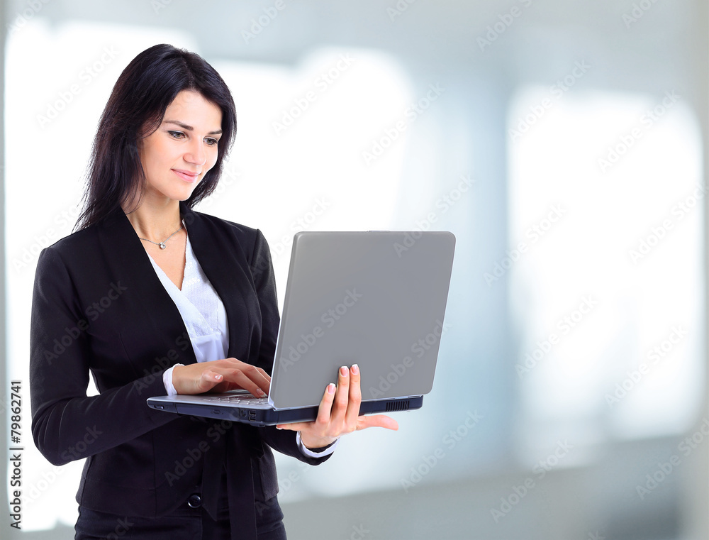 Businesswoman working at a laptop full length Businesswoman working at a laptop full length