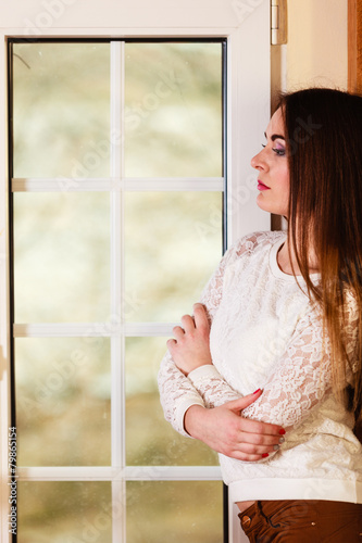 Beautiful woman looking through window.