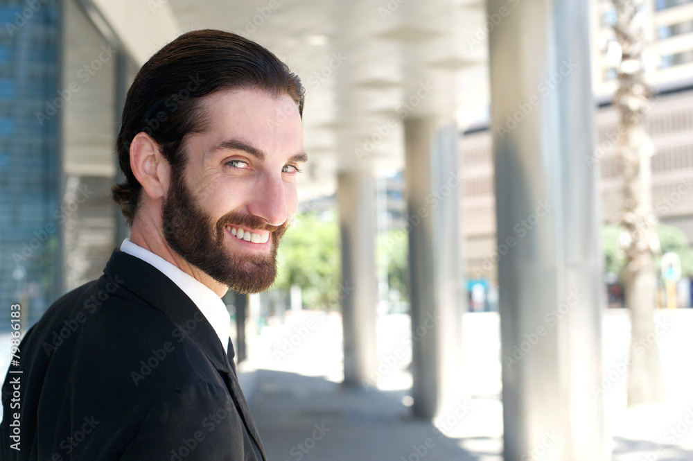 Happy businessman turning over shoulder and smiling Happy businessman turning over shoulder and smiling