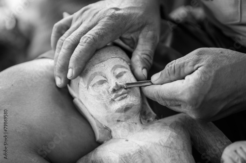 Hand of carver carving wood in blackand white color tone photo