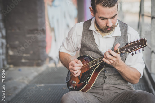 handsome big moustache hipster man playing mandolin photo