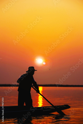 Silhouette of men rowing boat