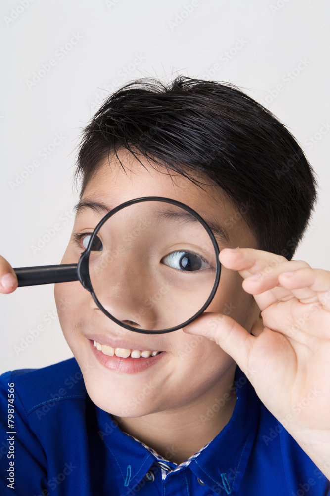 portrait of a young asian child looking through a magnifying gla portrait of a young asian child looking through a magnifying gla