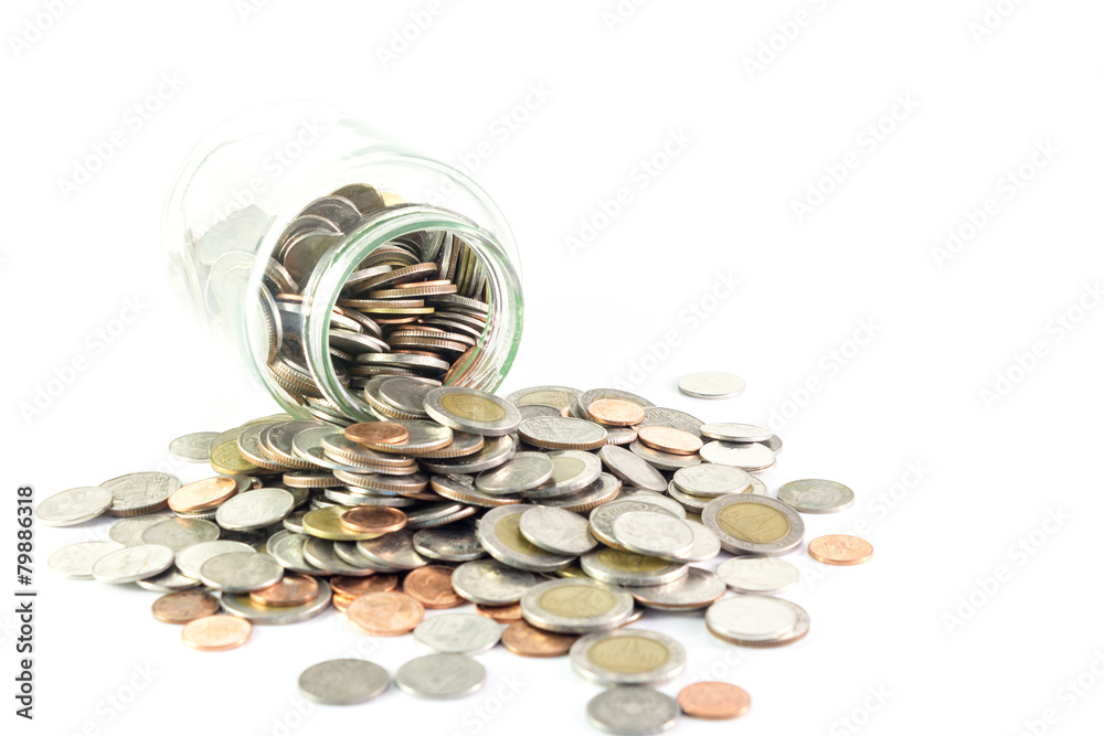 Isolated coins spilling from a money jar Isolated coins spilling from a money jar