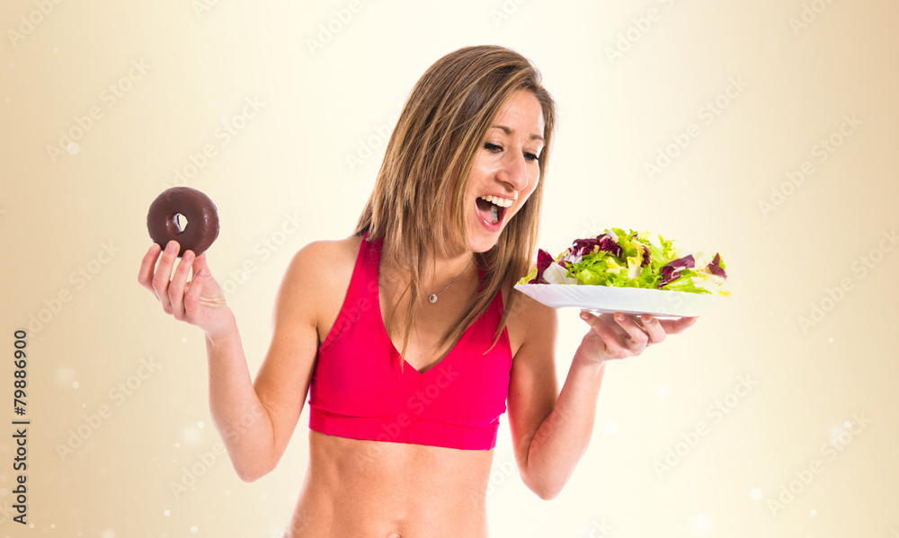 woman undecided between a donut and a salad