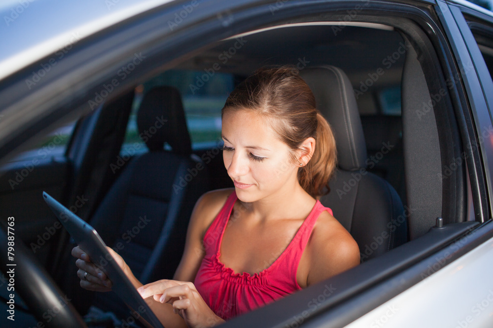 Pretty, female driver using her tablet computer