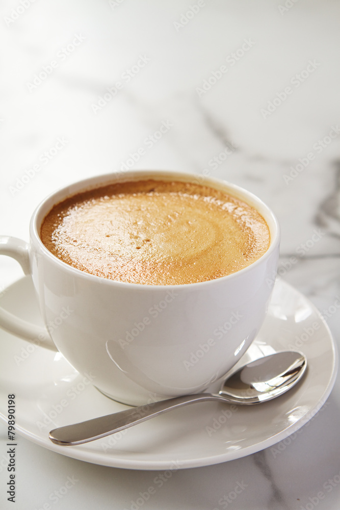 Cappucino or latte milk coffee in white cup and saucer in a cafe Cappucino or latte milk coffee in white cup and saucer in a cafe