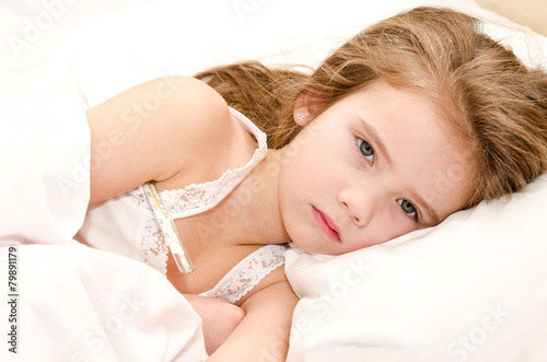 Sick little girl lying in the bed
