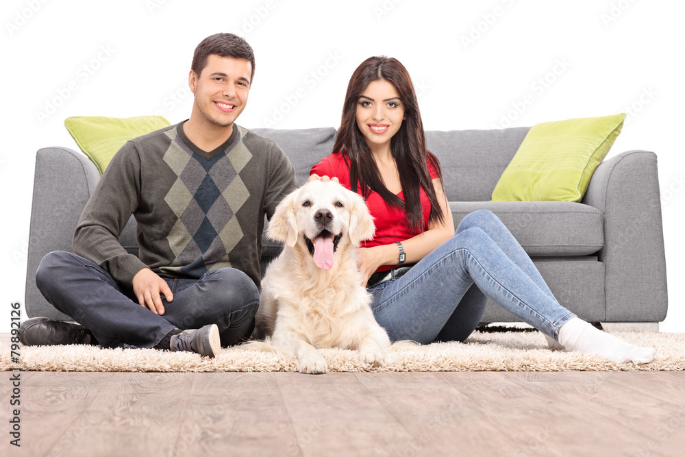 Young couple sitting on the floor with a dog Young couple sitting on the floor with a dog
