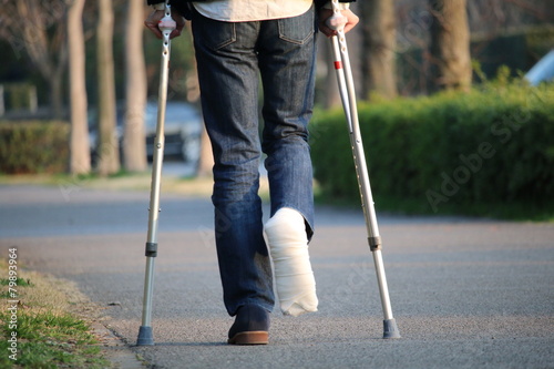 松葉杖で夕焼け道を行く